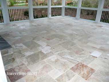 An angled close view shows cream and reddish mixed-size tiles extending toward screened porch railings.